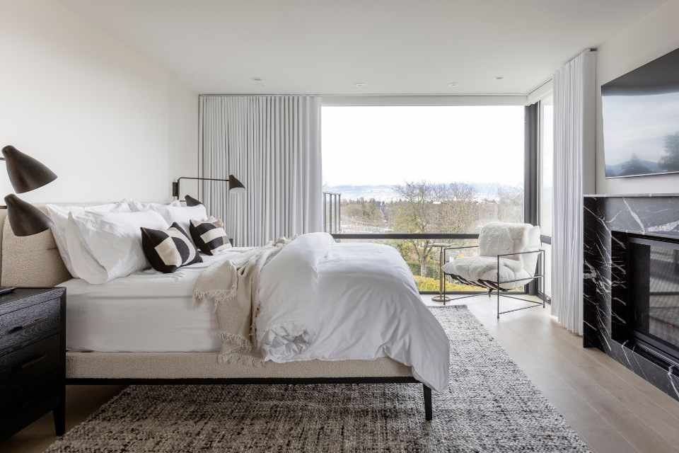 quiet luxury bedroom with neutral colour palette and black marble fireplace